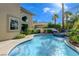 Beautiful blue pool area with a connected spa and lush tropical landscaping at 2440 Ping Dr, Henderson, NV 89074