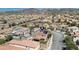 An aerial shot shows a two-story home with solar panels, a fenced yard, and community with mountain views at 2529 Flodden St, Henderson, NV 89044