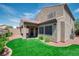 View of the house with a covered patio and a well-maintained lawn surrounded by decorative rock at 2529 Flodden St, Henderson, NV 89044