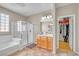 Bright bathroom features a glass shower, tub, and wooden vanity with ample storage and a walk in closet at 2529 Flodden St, Henderson, NV 89044