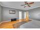 Spacious bedroom with hardwood floors, ceiling fan, mounted TV and a view of the landing at 2529 Flodden St, Henderson, NV 89044