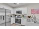Modern kitchen with stainless steel appliances, white cabinets, and granite countertops at 2598 Polar White Ave, North Las Vegas, NV 89086