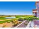 Backyard view overlooking golf course, lake, and mountains, complete with stone patio and outdoor seating at 2784 Cherrydale Falls Dr, Henderson, NV 89052