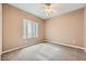 This bedroom is spacious and features neutral walls, carpet, and a ceiling fan at 2784 Cherrydale Falls Dr, Henderson, NV 89052