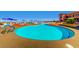 Large community pool with lounge chairs and umbrellas, set against a desert landscape at 2784 Cherrydale Falls Dr, Henderson, NV 89052