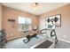 This home gym features neutral walls, carpet, a ceiling fan, and fitness equipment at 2784 Cherrydale Falls Dr, Henderson, NV 89052