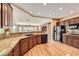 Kitchen with granite countertops, wood cabinets, stainless appliances and hardwood floors at 2784 Cherrydale Falls Dr, Henderson, NV 89052