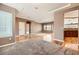 Open living space with hardwood floors, neutral walls, and large window with kitchen in the background at 2784 Cherrydale Falls Dr, Henderson, NV 89052