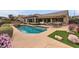 Inviting backyard pool with patio furniture, lush landscaping and desert accents at 2784 Cherrydale Falls Dr, Henderson, NV 89052