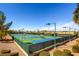 Overhead view of multiple, well-maintained tennis courts with green fencing and desert landscaping at 2784 Cherrydale Falls Dr, Henderson, NV 89052