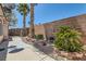 Well-maintained backyard features lush landscaping, a brick wall, and a paved walkway for easy access at 2889 Anteres St, Las Vegas, NV 89117