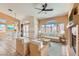 Bright staged living room with wicker furniture, tile flooring, fireplace, and ceiling fan at 2889 Anteres St, Las Vegas, NV 89117
