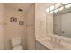Bright bathroom featuring a vanity with a large mirror and lighting fixture, a toilet, and towel racks at 3111 Bel Air Dr # 23A, Las Vegas, NV 89109