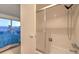 Bathroom with shower-tub and sliding glass door, plus partial view of bedroom and outdoor skyline at 3111 Bel Air Dr # 23A, Las Vegas, NV 89109