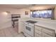 Bright kitchen featuring white appliances, tile floors, bar seating, and city views at 3111 Bel Air Dr # 23A, Las Vegas, NV 89109
