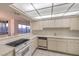 Bright kitchen features a city view, tile floors, white cabinets, and a pass-through to the dining area at 3111 Bel Air Dr # 23A, Las Vegas, NV 89109