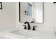 Close up on a modern sink with black fixtures and a bright white countertop at 3320 Osage Ave, Las Vegas, NV 89101