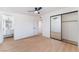 Bedroom featuring sleek ceiling fan, mirrored closet doors, wood floors, and adjacent bathroom at 3320 Osage Ave, Las Vegas, NV 89101