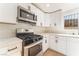 Close up of the kitchen featuring quartz countertops, stainless steel appliances, white cabinets, and a window view at 3320 Osage Ave, Las Vegas, NV 89101