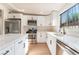 Bright kitchen with white cabinets, stainless steel appliances, an island, quartz countertops, and natural light from a window at 3320 Osage Ave, Las Vegas, NV 89101