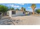 Side view of a home with white exterior, xeriscape landscaping, and a secure gate at 3320 Osage Ave, Las Vegas, NV 89101