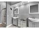 Stylish bathroom featuring double sinks, mirrored cabinet, and walk-in shower with glass door at 4005 Poppy Fields Dr, Las Vegas, NV 89129