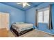 Bright bedroom featuring blue walls, ceiling fan and carpeted floors at 4005 Poppy Fields Dr, Las Vegas, NV 89129