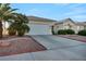 Inviting single-story home with a wide driveway, desert landscaping, and a well-maintained exterior at 4005 Poppy Fields Dr, Las Vegas, NV 89129