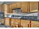 Functional kitchen featuring granite countertops, wooden cabinets, and updated appliances at 4005 Poppy Fields Dr, Las Vegas, NV 89129