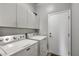 Functional laundry room with Maytag washer/dryer, overhead storage, and convenient access door at 4005 Poppy Fields Dr, Las Vegas, NV 89129