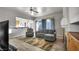 Comfortable living room with wood-look flooring, large windows, access to the kitchen, and cozy seating at 4005 Poppy Fields Dr, Las Vegas, NV 89129