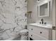 Elegant powder room with marble tiled accent wall, sleek vanity, and modern fixtures at 401 Sonoma Valley St, Las Vegas, NV 89144