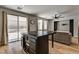 Open living space featuring a dark kitchen island, recessed lighting, and backyard access at 401 Sonoma Valley St, Las Vegas, NV 89144