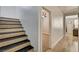 Modern staircase with wood-look steps, leading to a doorway with a glimpse of a bedroom, featuring a ceiling fan at 401 Sonoma Valley St, Las Vegas, NV 89144