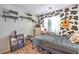 Fun bedroom design with black and white cow print, guitar, bed and wood floors at 4037 Asante Cove St, Las Vegas, NV 89115
