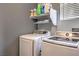 A laundry room features modern appliances, upper shelf storage and natural light from a window at 4037 Asante Cove St, Las Vegas, NV 89115