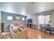 Inviting living area with a cozy sectional sofa, wood floors, and a dining table, ideal for entertaining and relaxation at 4037 Asante Cove St, Las Vegas, NV 89115