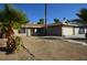 Cozy single-story home with a two-car garage and mature palm trees in the desert landscaped yard at 4354 Thorndale Pl, Las Vegas, NV 89103