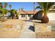 Attractive single-story home with stone-lined garden and mature palm trees in the front yard at 4354 Thorndale Pl, Las Vegas, NV 89103