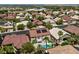 Expansive aerial view showcases neighborhood homes, many with solar panels, and a beautiful backyard with a pool at 464 Beardsley Cir, Henderson, NV 89052