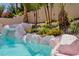 Inviting backyard pool featuring a rock waterfall and lush landscaping, creating a serene oasis at 464 Beardsley Cir, Henderson, NV 89052
