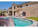 Backyard pool with a rock waterfall feature, lounge chairs, and a well-manicured lawn at 464 Beardsley Cir, Henderson, NV 89052