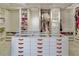 Spacious walk-in closet with custom shelving, drawers, and a central island featuring a glass top at 464 Beardsley Cir, Henderson, NV 89052