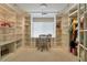 Bright walk-in closet with custom shelves, drawers, and a built-in desk, perfect for organizing clothes and accessories at 464 Beardsley Cir, Henderson, NV 89052