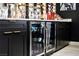 Custom wet bar with beverage center, black cabinetry and sleek hardware at 464 Beardsley Cir, Henderson, NV 89052