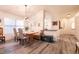 Stylish dining area with a rustic wooden table, large windows, and modern light fixture at 5028 Glenarden Dr, Las Vegas, NV 89130