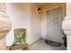 Charming front porch with a secure screen door, stylish light fixture, and cozy wicker chair at 5028 Glenarden Dr, Las Vegas, NV 89130
