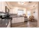 Well-lit kitchen with stainless steel appliances, white cabinetry, and wood-style laminate flooring at 5028 Glenarden Dr, Las Vegas, NV 89130