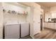 Convenient laundry room with a washer, dryer, and built-in shelving for storage, adjacent to the kitchen at 5028 Glenarden Dr, Las Vegas, NV 89130