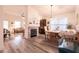 Bright and airy living room featuring a brick fireplace, dining area, and modern flooring at 5028 Glenarden Dr, Las Vegas, NV 89130